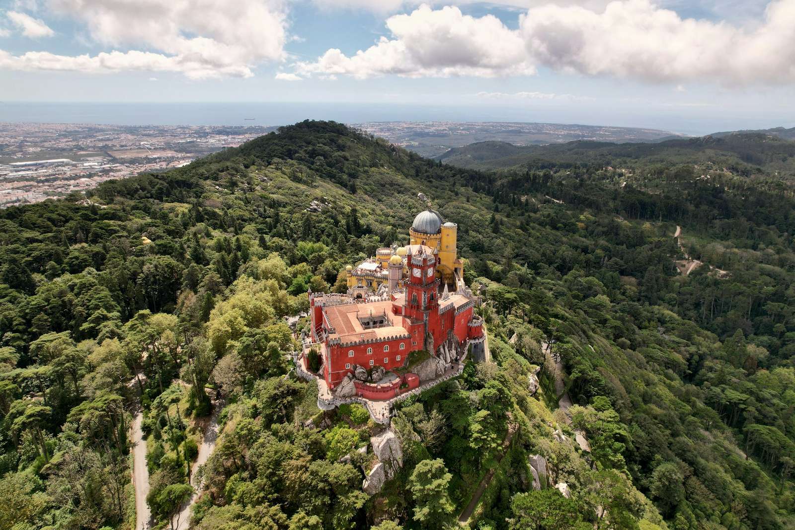 Aerial view of Pena Palace on its forested peak above Sintra